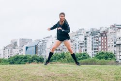 Sportswoman practicing yoga on lawn