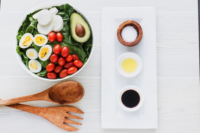 Spinach salad with eggs avocados tomatoes and mozzarella cheese