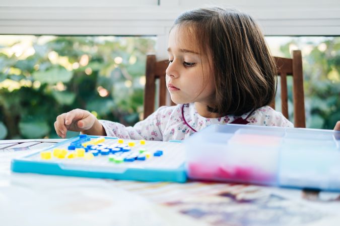 Girl playing with mosaic board game