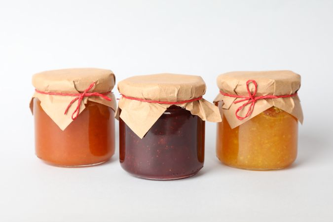 Glass jars with jam on blank background. Sweet food
