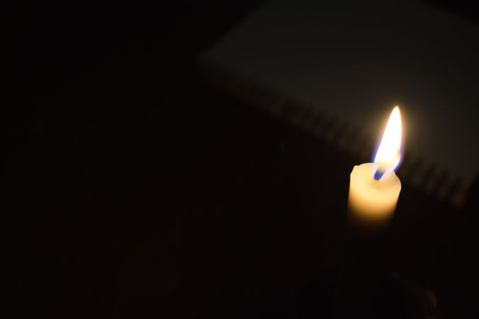 Top view of candle lit in the dark with space for text