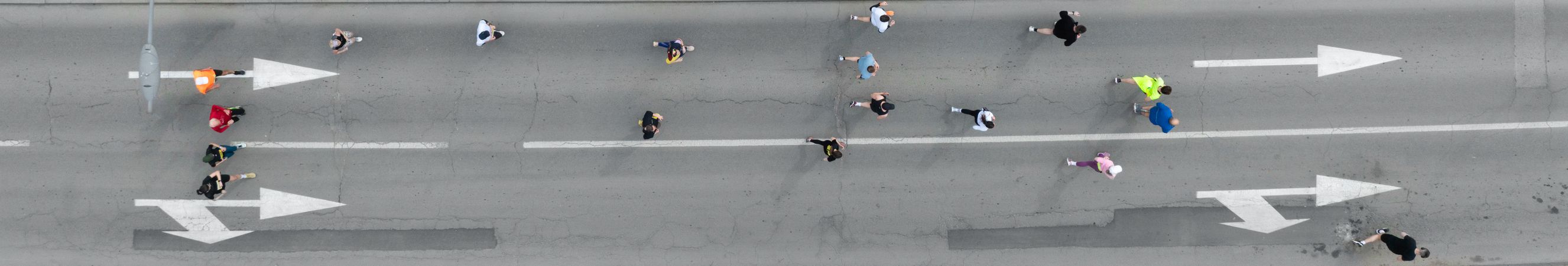 Aerial photo of a group of people running in one direction together.