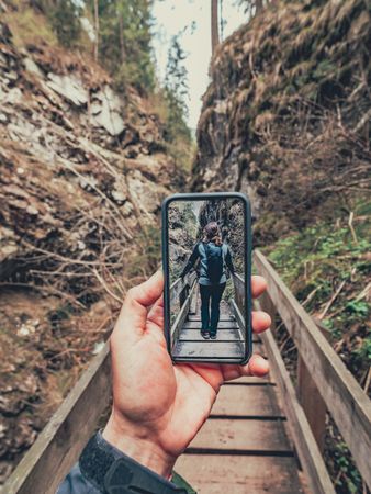 Tourist taking photo while walking on footpath