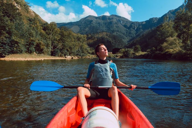 Young female kayaking on nature background
