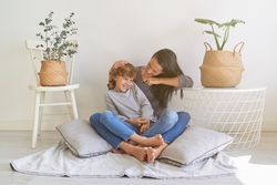 Mother tickling and embracing son at sunlight