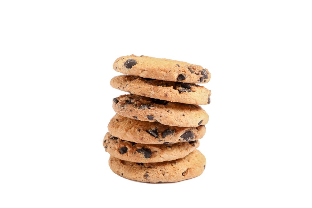 Stack of tasty chocolate chip cookies on white background