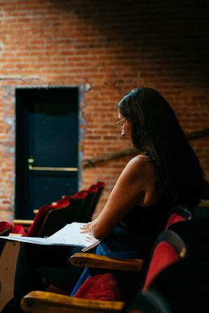 Female director sitting in theater with script