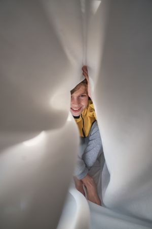 Cheerful boy lying in bed at home