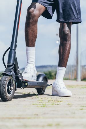 Black man riding on electric scooter in park