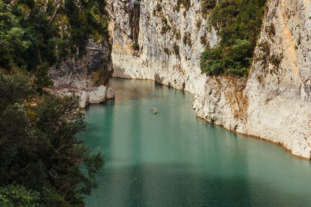 People crossing a river by kayak