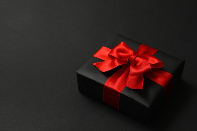 Gift box with red bow on dark background