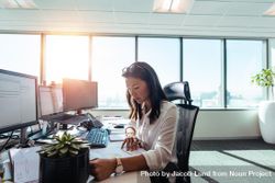 Focused woman sitting at desk in corporate office 5QnqG4