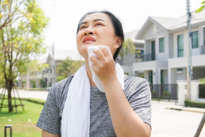 Woman using towel to wipe face after workout