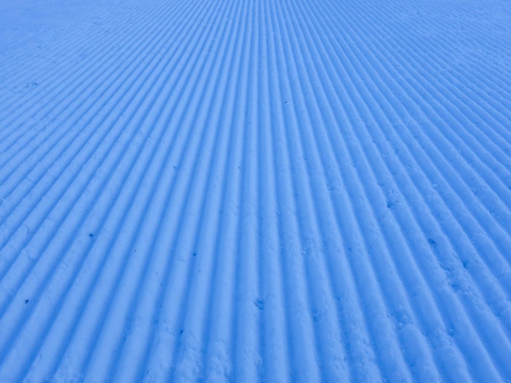 Ski slope grooves and ridges made by snow groomer