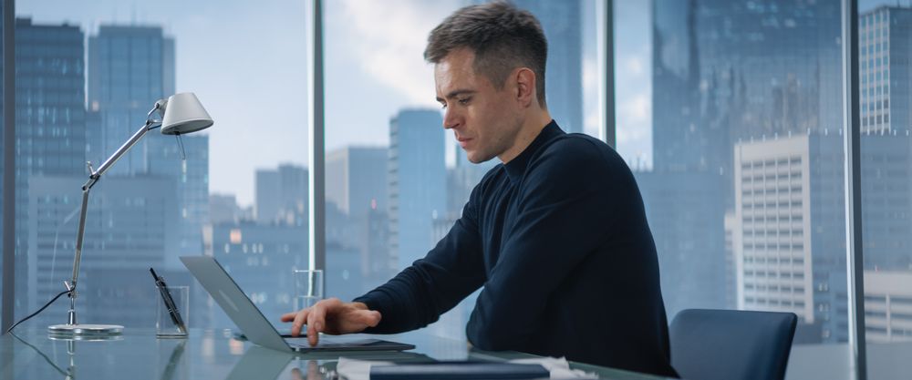 Creative Businessman in a Turtleneck Jumper Sitting in Modern Office