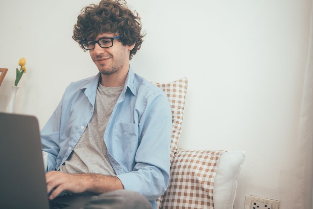 Freelancer man sitting on bed taking a video call