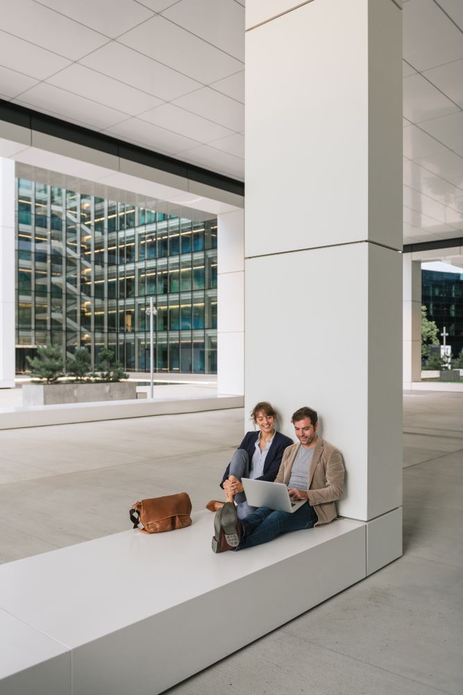 Cheerful colleagues using laptop on street