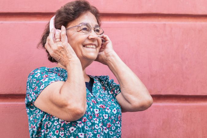 Mature woman in colorful clothes and modern headphones