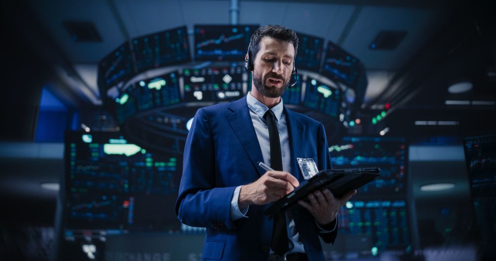 Productive Stock Exchange Broker Working on a Tablet Computer, Manipulating Company Shares, Valuable Technology Investments, Public and Private Securities.