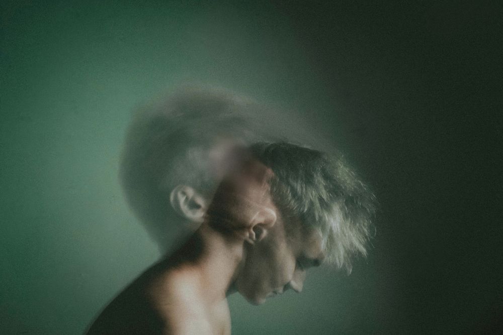 Long exposure of topless man moving his head back and forward