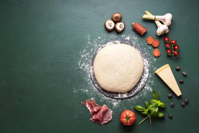 Pizza ingredients and raw dough on table
