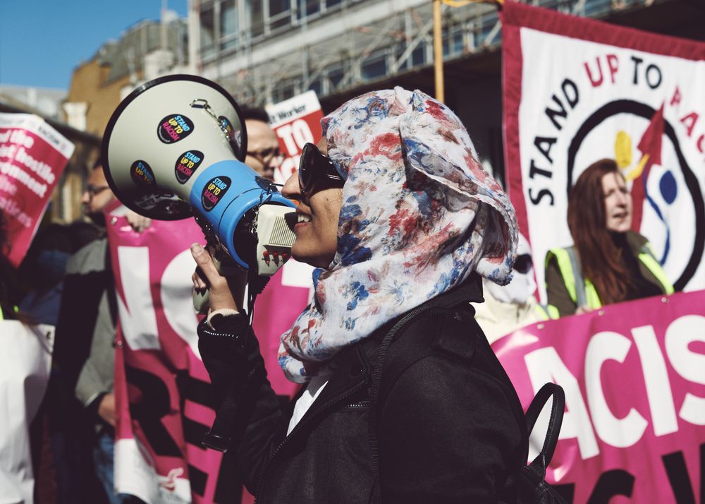 London, England, United Kingdom - March 19 2022: Smiling woman with mega phone at rally