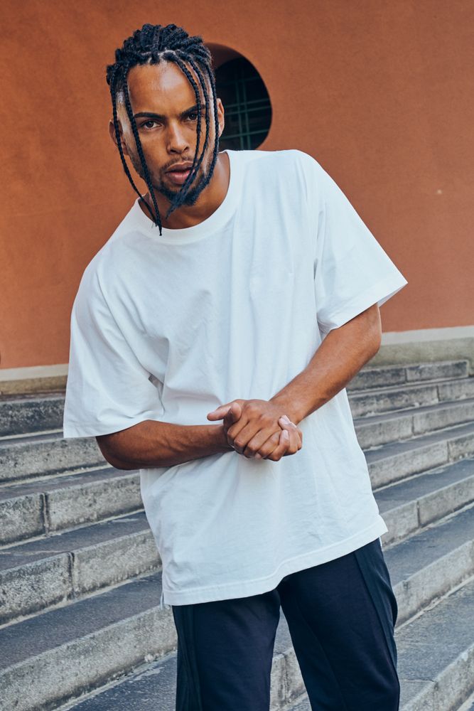 Trendy Black man posing near modern arch