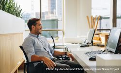 Entrepreneur sitting relaxed at desk in office 5wXgg6