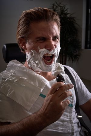 Man with foamy beard pretending to sing