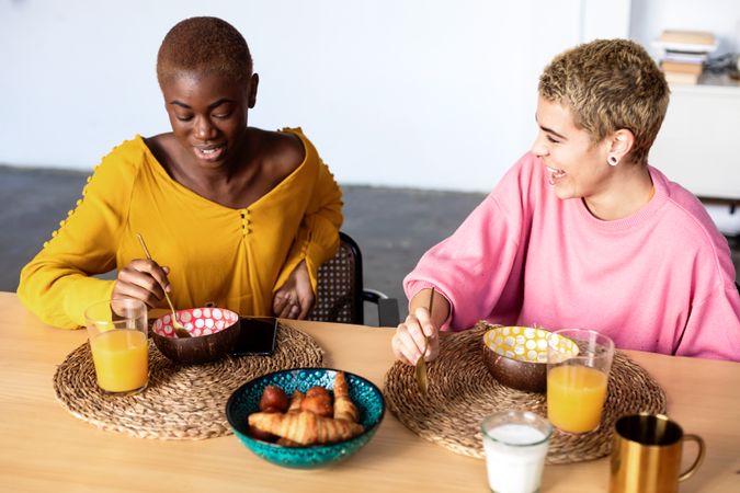 Two multi-ethnic girlfriends having breakfast together at home