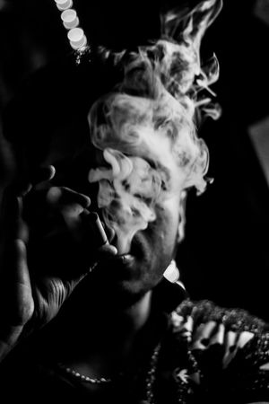 Grayscale photo of man smoking