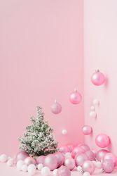 Baubles in a variety of pink shades in corner of pink room with Christmas tree