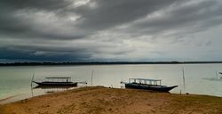 Boats on remote sandy beach in clouds