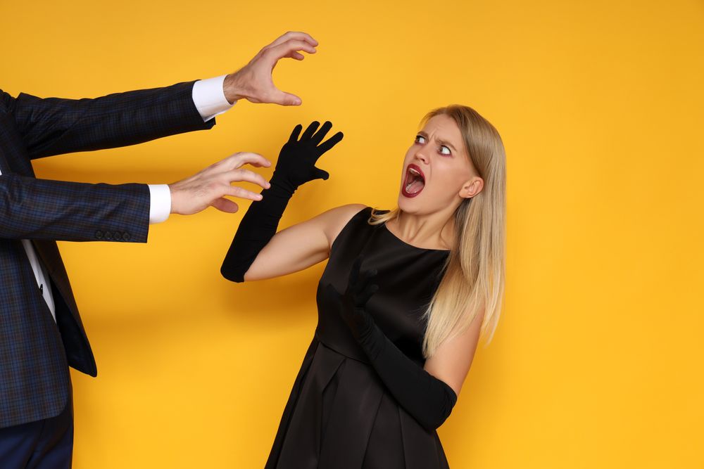 Concept of Halloween, young woman on yellow background