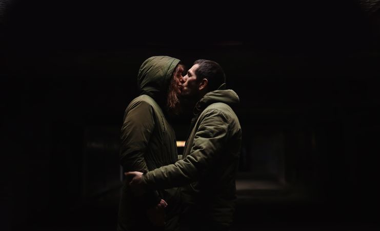 A couple's kiss in the darkness.