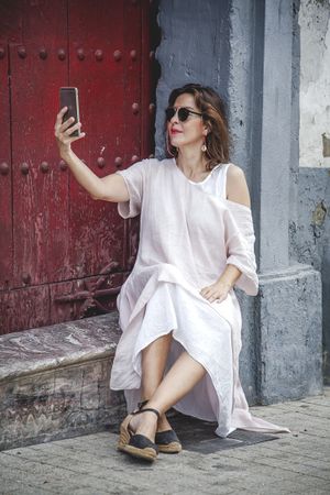 Relaxed female taking selfie with phone on street