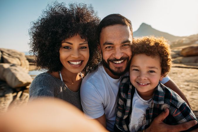 Close up shot of a smiling couple with a kid on a holiday.