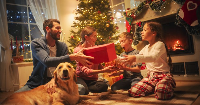 Happy Little Family Exchanging Gifts on Christmas Eve: Brother and Sister Receiving their Gifts.