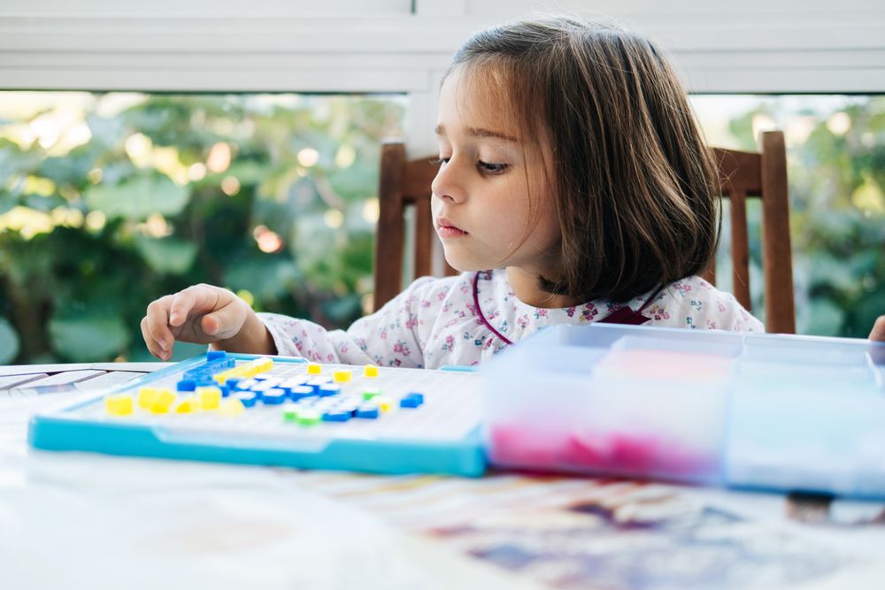 Girl playing with mosaic board game