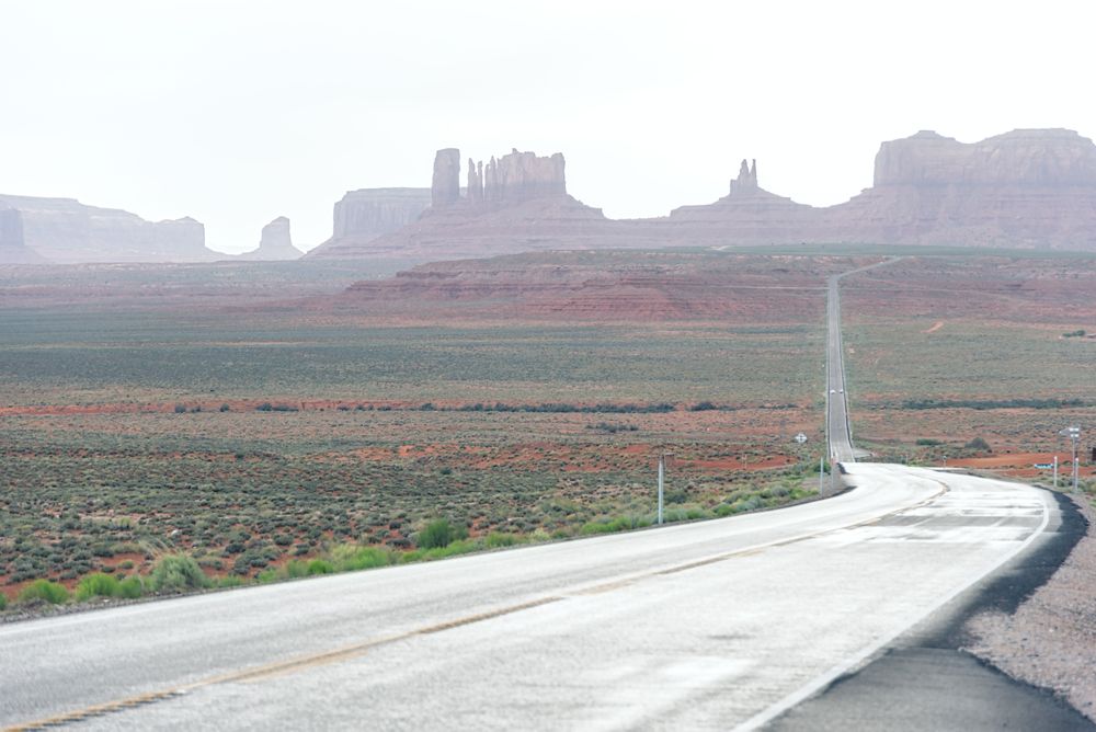 Asphalt road at scenic mountain valley and power line