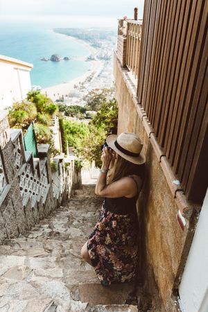 Stylish woman picturing coast from stairway