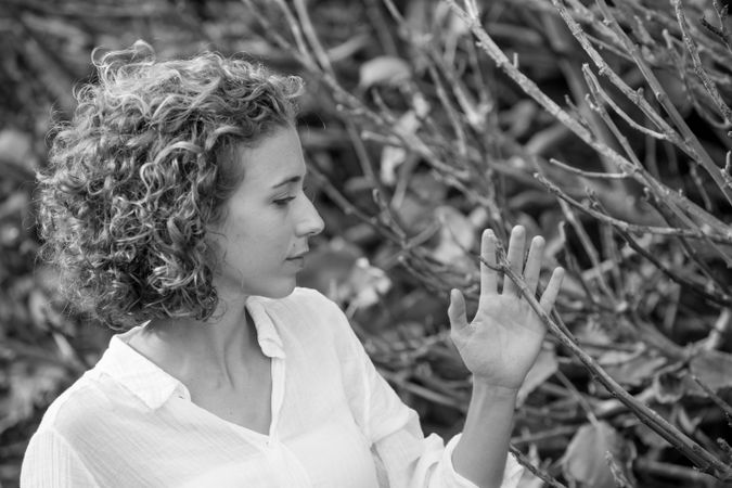 Young woman near dry twigs of bushes