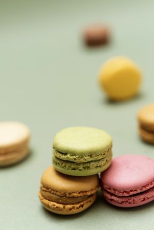Scattered pastel colored macaroons over a green background