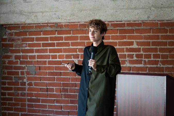 Nonbinary person pausing while public speaking