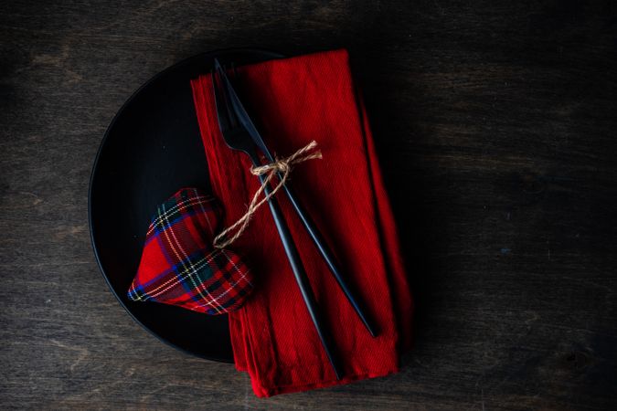 Top view of Valentine's table setting with red napkin and tartan heart with space for text