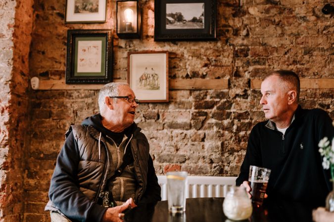 Two mature men having drinks at a pub