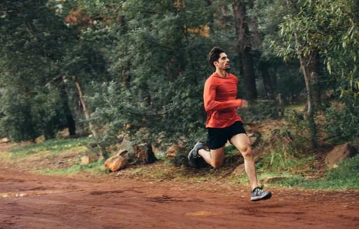 Man running on outdoor mud track