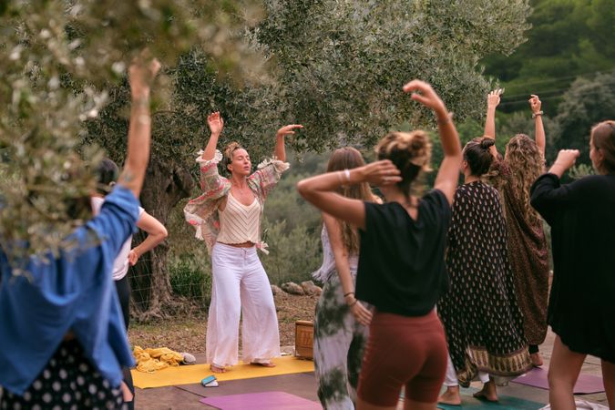 Group of women performing breathing exercises with raised hands
