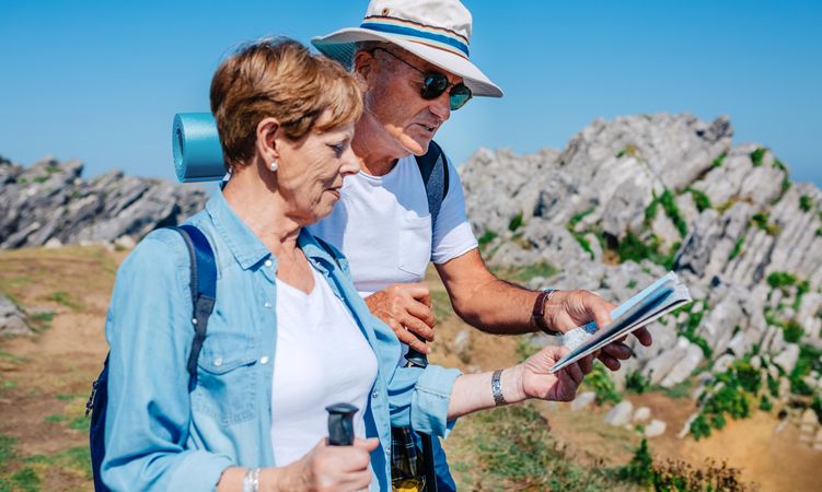 Mature couple checking map on trek