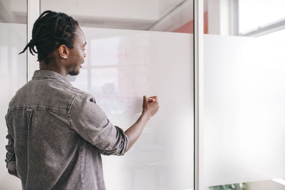 Young man with pie chart on a whiteboard